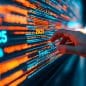 A hand reaches towards a digital interface displaying colorful data streams, highlighting trends and projections for the year 2025.