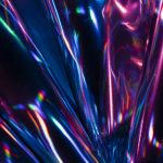 Closeup of spectrum light reflections on holographic metal foils lit by neon lights