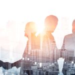Double exposure image of many business people conference group meeting on city office building in background showing partnership success of business deal. Concept of teamwork, trust and agreement.